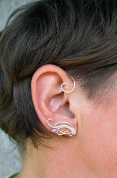 ORDERS PLACED AFTER DECEMBER 1, MAY ARRIVE AFTER CHRISTMAS OR NEW YEAR EVE due to the postal services being overwhelmed this time of year. Average delivery terms USA, France, Ireland - 3-4 weeks Australia, Canada - 4-6 weeks Netherlands, Spain - 2-3 weeks Please message me if you are unsure of dates before ordering. A pair of ear cuffs made of silver plated copper wire, glass and silver plated beads. The piece is covered by metal protecting lacquer. No piercing needed. Made for medium size ears Metal Ear Cuff As A Gift, Adjustable Silver Ear Cuff With Ear Wire, Dainty Silver Ear Cuff For Wedding, Adjustable Sterling Silver Ear Cuff With Ear Wire, Delicate Ear Cuff As A Gift, Silver Ear Cuff For Gift, Silver Ear Cuff For Pierced Ears Gift, Sterling Silver Ear Cuff With Ear Wire For Weddings, Unique Silver Pierced Ear Cuff