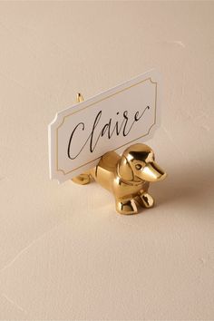 a gold elephant holding a sign that says claise