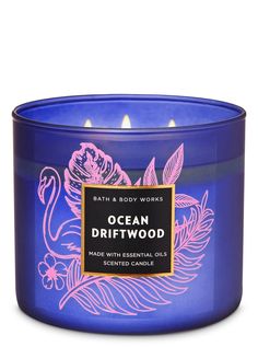 bath and body works ocean driftwood scented candle in a blue glass container with pink flowers