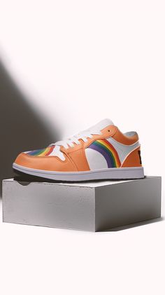 an orange sneaker with multi - colored stripes on the side and white soles