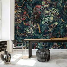 a dining room table and chairs in front of a wall with skulls, flowers and leaves on it