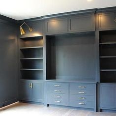 an empty room with built - in bookshelves and cabinets