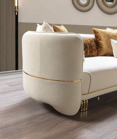 a white couch sitting on top of a wooden floor next to a wall with mirrors