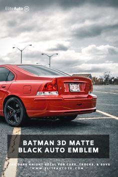 a red car parked in a parking lot with the words batman 3d matte black auto emblem