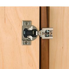 a close up of a door handle on a wooden cabinet