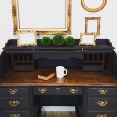 an antique desk with two mirrors and a cup on it