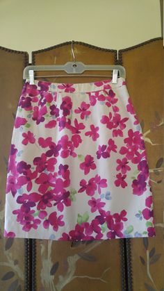 Bright and summery Y2K flowered Moschino cheap and chic brand mini skirt. Ivory back ground with pink and purple watery print flowers. Pockets at sides. Zip at side. Lined with beige fabric. USA size 6 GB size 8 EUR size 36 51% silk / 49% rayon Made in Italy Waist 27" Hips 38" Length 21" Floral Print Pencil Mini Skirt For Summer, Summer Floral Print Purple Skirt, Summer Purple Floral Print Skirt, Purple Floral Print Skirt For Summer, Purple Floral Print Skirt For Spring, Spring Purple Floral Print Skirt, Purple Floral Skirt For Spring, Summer Floral Print Purple Mini Skirt, Summer Purple Floral Print Mini Skirt