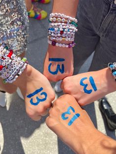 four people holding hands with numbers painted on them