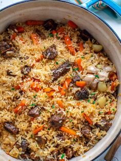 a pot filled with rice and vegetables on top of a table