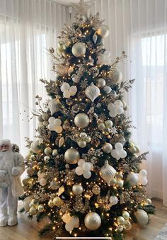 a white christmas tree with gold and silver ornaments