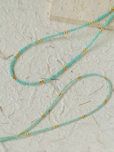 Crafted with exquisite Amazonite gemstones and delicately intertwined with shimmering gold beans, this necklace exudes elegance and sophistication. Elevate your look with its subtle yet striking beauty, perfect for any occasion. Whether worn alone or layered with other pieces, this necklace is sure to make a statement wherever you go. Metal: 18K Recycled Gold Plated On Brass Gemstone: Amazonite(2-2.5mm/3-3.5mm) Length: 410-450mm Weight: 4-6g Adjustable Elegant Emerald Necklace With Round Beads, Elegant Adjustable Emerald Necklace With Round Beads, Elegant Gold Beaded Necklace With Tiny Beads, Elegant Emerald Necklace With Beaded Chain, Adjustable Beaded Emerald Necklace In Elegant Style, Elegant Adjustable Beaded Emerald Necklace, Elegant Yellow Gold Beaded Necklace, Delicate Gemstone Beaded Necklaces, Gold Dainty Rondelle Beaded Necklaces