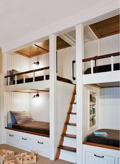 the bunk beds are built into the wall in this kids's room with ladders