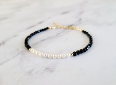 This dainty little bracelet is made from natural precision cut black spinels and white freshwater seed pearls. The size of the beads are around 3mm, perfect  as a stacking bracelet. Both gold filled and sterling silver finishings are available at your choosing. The length is 6.5 inches with 1 inch extension chain. Please message me if you need a customized size or without extension chain, I need to confirm availability first as my supplies are very limited.  Please note that while I try my best Black Beaded Pearl Bracelets, Black Pearl Bracelets With Round Beads, Black Pearl Bracelets As Gift, Black Pearl Bracelets For Gifts, Black Pearl Bracelets For Gift, Elegant White Bracelets With Black Beads, Elegant White Bracelet With Black Beads, Black Pearl Bracelet As A Gift, Pearl Bracelet Gold