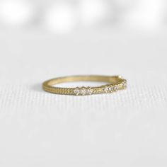 This unique diamond ring is a stunning addition to any jewelry collection. The 14k yellow gold band is complemented by elegant 12 white diamonds and raw material 'buttons', creating a beautiful and eye-catching design. It can serve as a perfect wedding ring or a chic add-on to your main boho rings for a luxurious bohemian look. Make a statement with this exquisite piece that combines the natural beauty of raw materials with the glamour of diamonds. Gia Certified Diamond Gold Cluster Ring, Delicate 14k Gold Stackable Diamond Ring, Dainty 14k Gold Stackable Diamond Ring, Delicate Stackable Yellow Gold Diamond Ring, Bohemian Rings With Raw Stone, Triple Diamond Ring, Luxury Bohemian, Raw Gold, Unique Diamond Ring