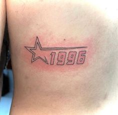 a person with a star tattoo on their back and the number 1950 written in white ink