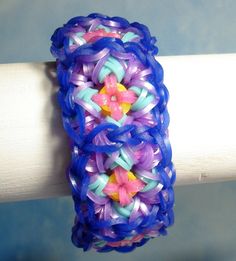 a close up of a bracelet made out of plastic beads on a white piece of wood