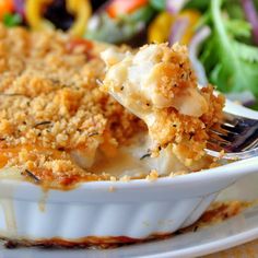 a close up of a casserole on a plate with a fork in it