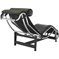 a black leather and chrome lounge chair with an ottoman on it's backrest