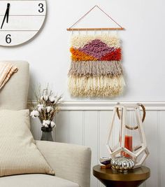 a living room with a large clock hanging on the wall next to a white chair