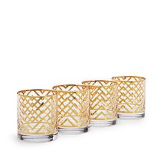 four gold - plated glass tumblers with geometric designs on the bottom and sides