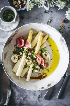 a white bowl filled with food on top of a table next to utensils