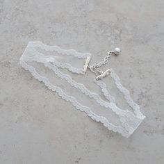 "This lovely ivory soft vintage lace choker necklace is made up in a scalloped and netted pattern. The lace portion of the choker is crimped with silver bars and there is an adjustable length of 13 1/2\" - 15\" with the extension chain accented with a glass pearl bead. There is a silver hook closure. The width of the lace is 1 \". If you need a different neck measurement I can make this choker to your length requirement. Just send me a message with your order and I will customize size for you. A Vintage White Crochet Lace For Elegant Style, Elegant Vintage White Crochet Lace, Vintage White Crochet Lace Fabric, Vintage Lace Jewelry For Weddings, Lace Choker With Lace Trim As Gift, Vintage Lace Wedding Jewelry, Vintage Lace Choker As A Gift, Vintage Lace Choker For Gifts, Feminine Adjustable Choker For Wedding