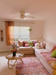 a living room filled with lots of furniture and colorful pillows on top of the couch