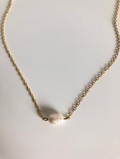 In the Philippines pearls are a national gem! They represent the richness of beauty the stunning sea life brings to the islands. A simple single pearl sits in the center of this gold filled chain. 15" long. White Single Strand Pearl Necklace With 14k Gold Filled, Elegant Gold Shell Necklace With Round Beads, Gold Pearl Pendant Necklace In 14k Gold Filled, Gold Pearl Charm Necklace With Pearl Drop, Gold Pearl Drop Charm Necklace, White Pearl Charm Necklace In 14k Gold, White Pearl Necklace With 14k Gold Charm, Minimalist 14k Gold Pearl Necklace With Pearl Charm, White 14k Gold Pearl Necklace With Charm