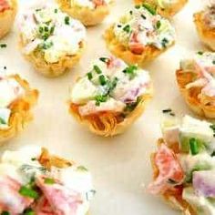 many small appetizers are arranged on a white tray and ready to be eaten