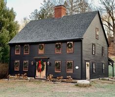 a black house with wreaths on the windows