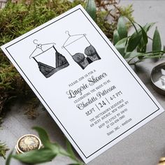 a wedding card with two bras on it next to some greenery and coins