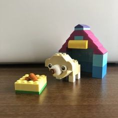 two lego animals are on the floor next to each other, one is eating food