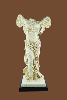 a statue of an angel with wings on a brown background