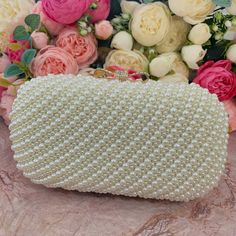 This luxurious encrusted pearl bridal clutch never fails to turn heads with its understated elegance and classic design. Adorned with varying sized ivory pearls and enhanced with a large creamy pearl clasp, this bridal clutch is the very picture of refinement. This elegant bridal clutch features rose gold trim, attachable chain and large enough for your phone. Complete your list of must-have wedding accessories with the ultimate bridal accessory to finish off your look and storing your wedding d Pearl Embellished Clutch, Pearl Clutch For Party, Elegant Pearl Evening Bag For Events, Formal Gold Clutch With Pearl Material, Formal Pearl White Evening Bag, Pearl Evening Bag With Pearl Handle For Wedding Guest, Pearl Clutch With Pearl Embroidery For Evening, Pearl Embellished Evening Bag For Party, Pearl White Clutch For Parties