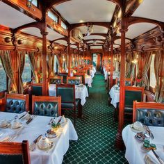 the interior of a train car with tables and chairs set up for formal dining,