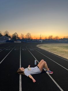 a person laying on the side of a race track with their feet in the air