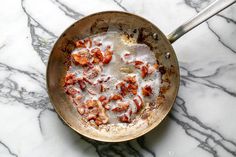 a pan filled with food sitting on top of a marble counter