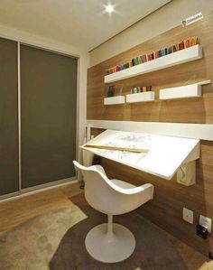 a white chair sitting in front of a desk with bookshelves on the wall