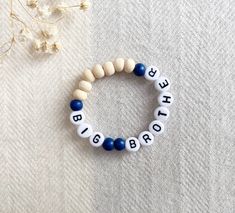 a beaded bracelet with the word big brother written in white and blue beads on it