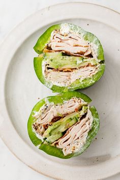 two halves of stuffed green peppers on a white plate