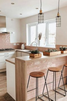 a kitchen with two bar stools next to a counter top and an open window