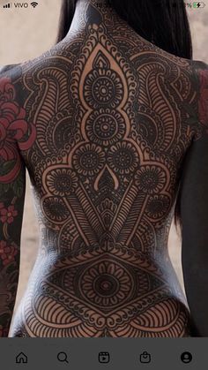 the back of a woman's body with tattoos on it