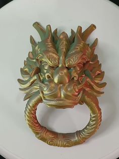 a gold dragon head ring on a white plate