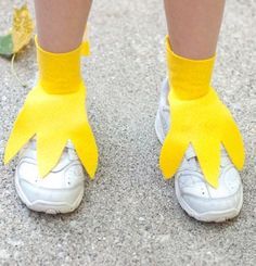 the legs and feet of a person wearing yellow socks with bows on them, standing in front of a leaf