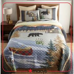 a bed with a bear quilt and pillows on it