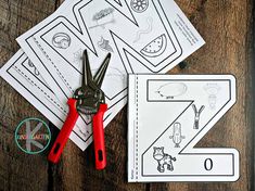 scissors and paper cut out to make a letter z worksheet for kids on a wooden table