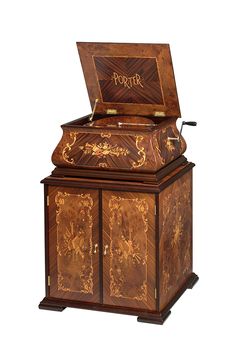 an ornately decorated wooden box with writing on the lid and bottom, sitting upright