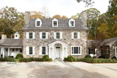 a large stone house with white trim and windows