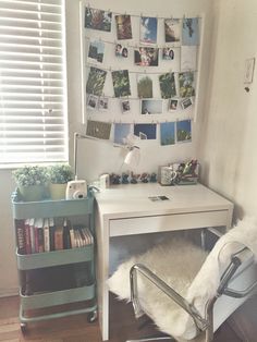 a white desk with a chair next to it and pictures on the wall behind it