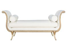 a white and gold bench with two pillows on it's back end, sitting in front of a white background